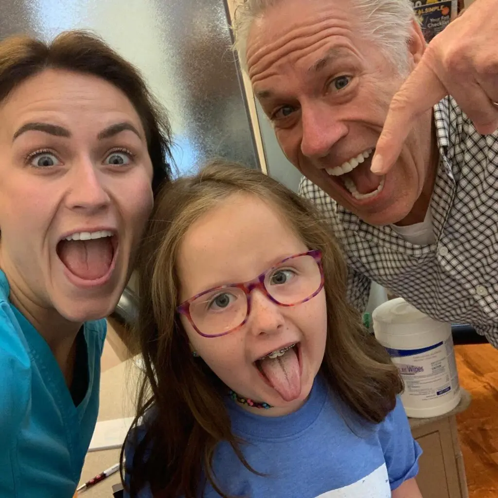 Dr. Roeder and staff member smiling with a happy patient