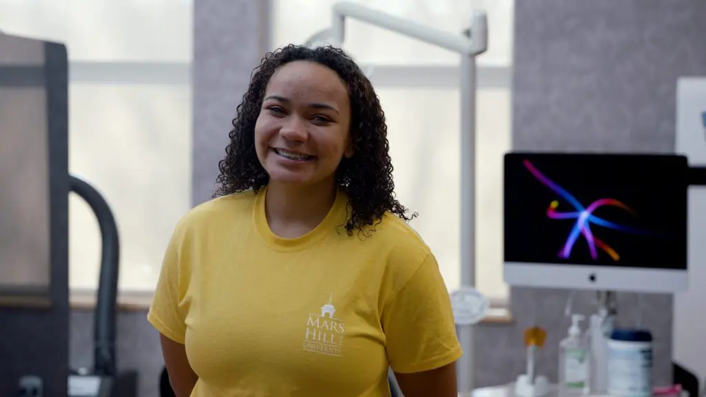teen girl in a yellow shirt with braces