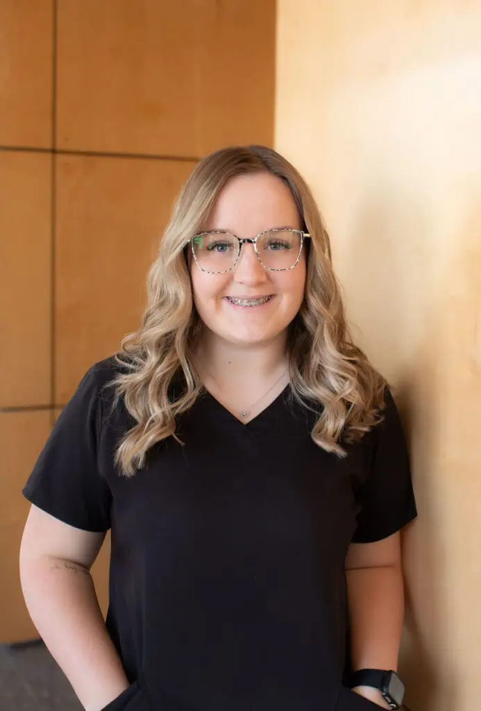 a woman wearing glasses and smiling