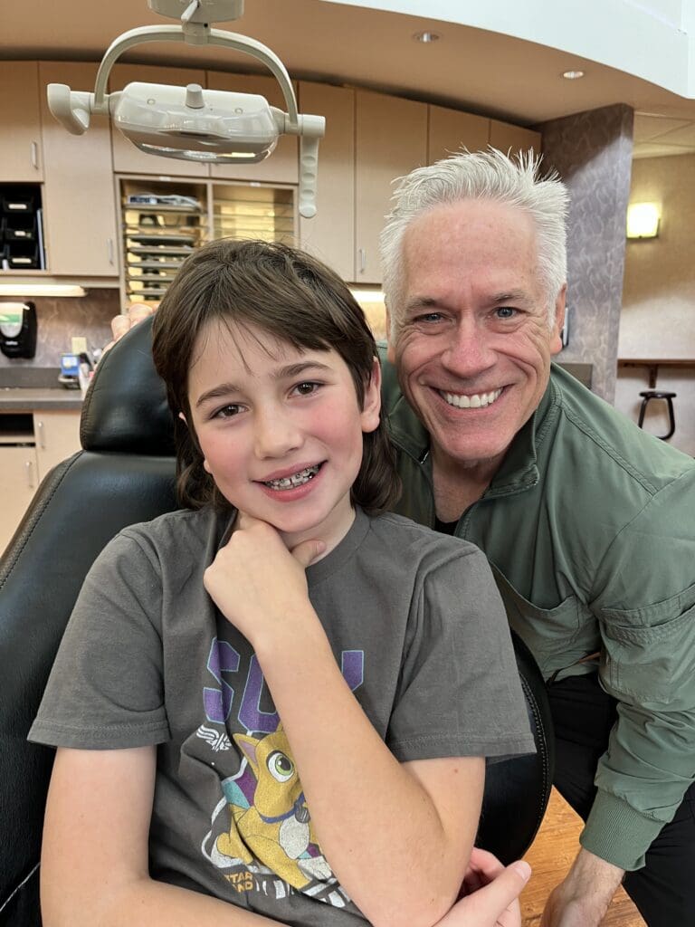 Dr. Roeder and a patient wearing traditional metal braces