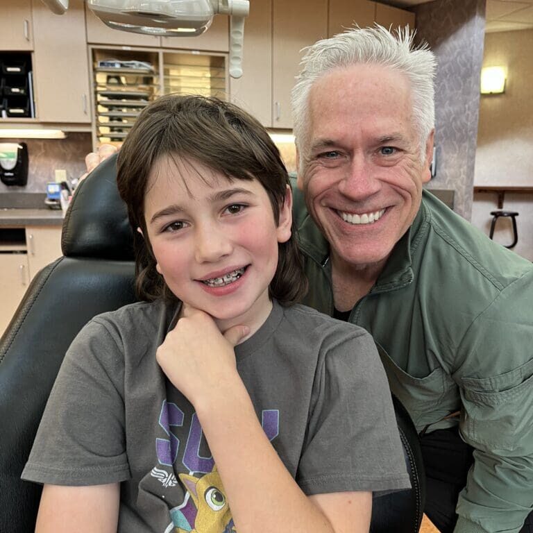 Dr. Roeder and a patient wearing traditional metal braces